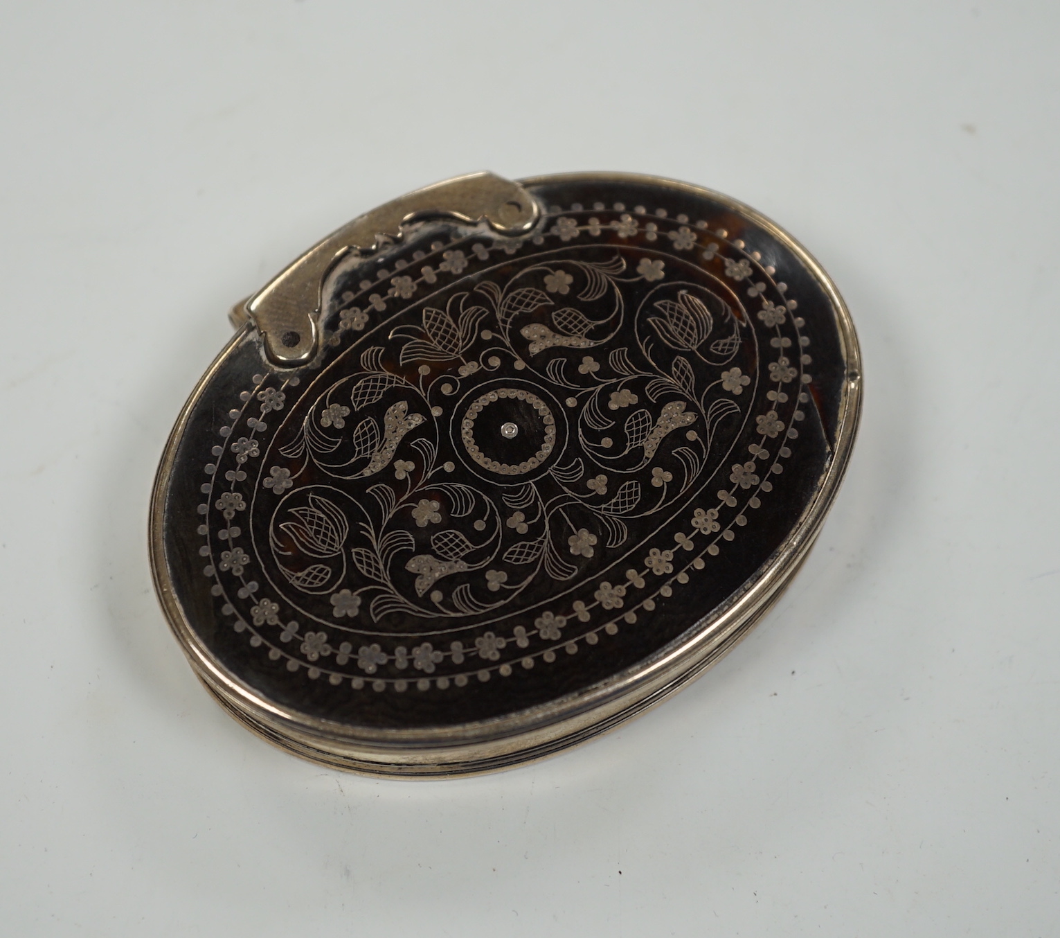 An 18th century white metal mounted tortoiseshell pique oval snuff box, 70mm.
